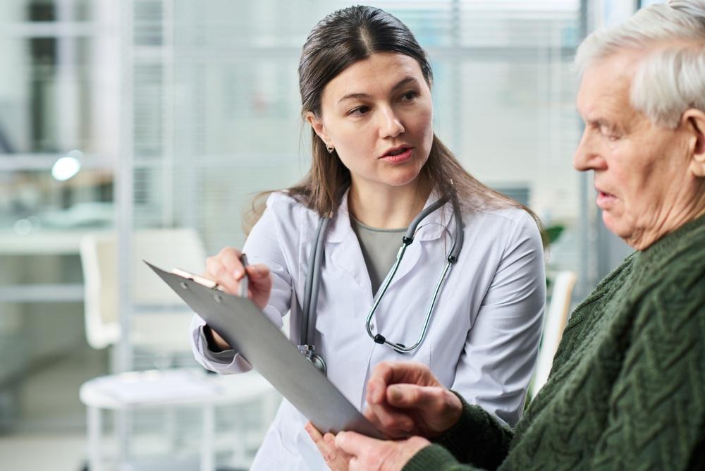 Doctor discussing Amyotrophic Lateral Sclerosis (ALS) Treatment Options with an older patient during a neurological consultation