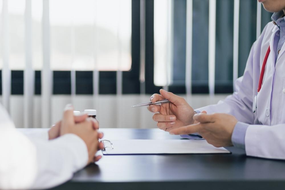 Physician discussing erectile dysfunction treatment options with a patient during a confidential review of medical and sexual history.